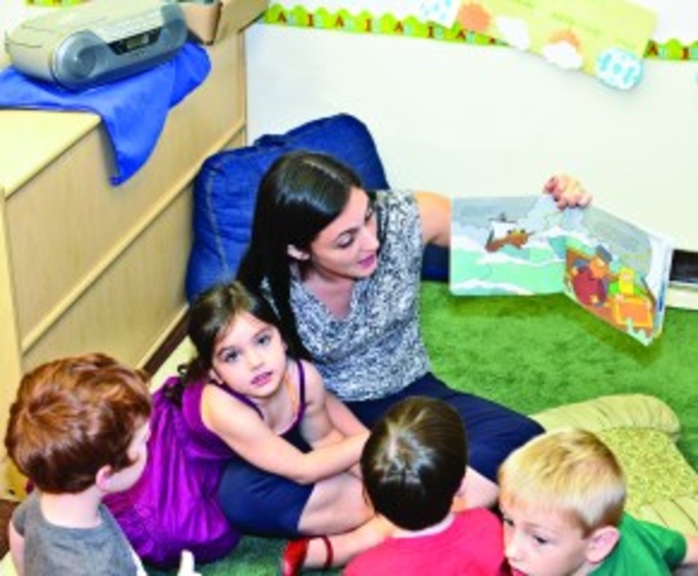 Parent Victoria Heimer reading a story to the children in the ECC’s newly added classroom. /Brian Sullivan
